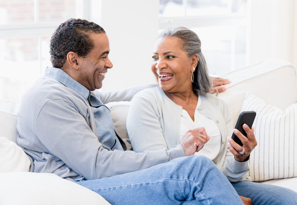 Couple on couch looking at cell phone