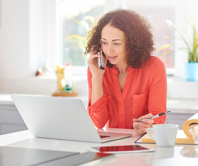 Women working on laptop while talking on phone