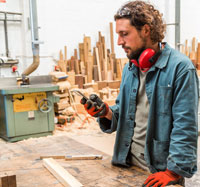 Man in carpentry shop on cell phone