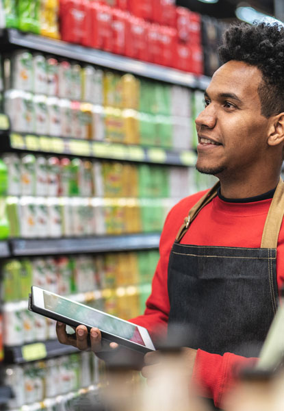 Man working at grocery store taking inventory on tablet