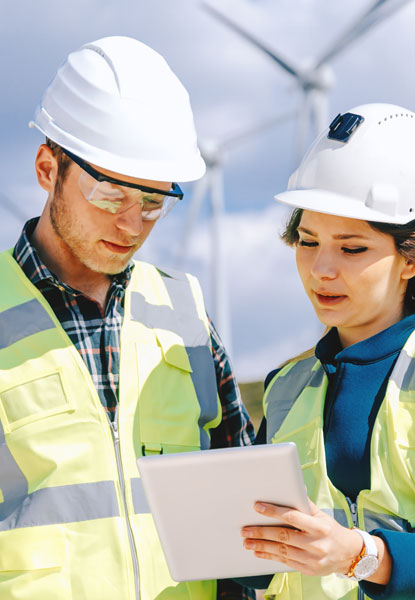 Two engineers in the field looking at a clipboard