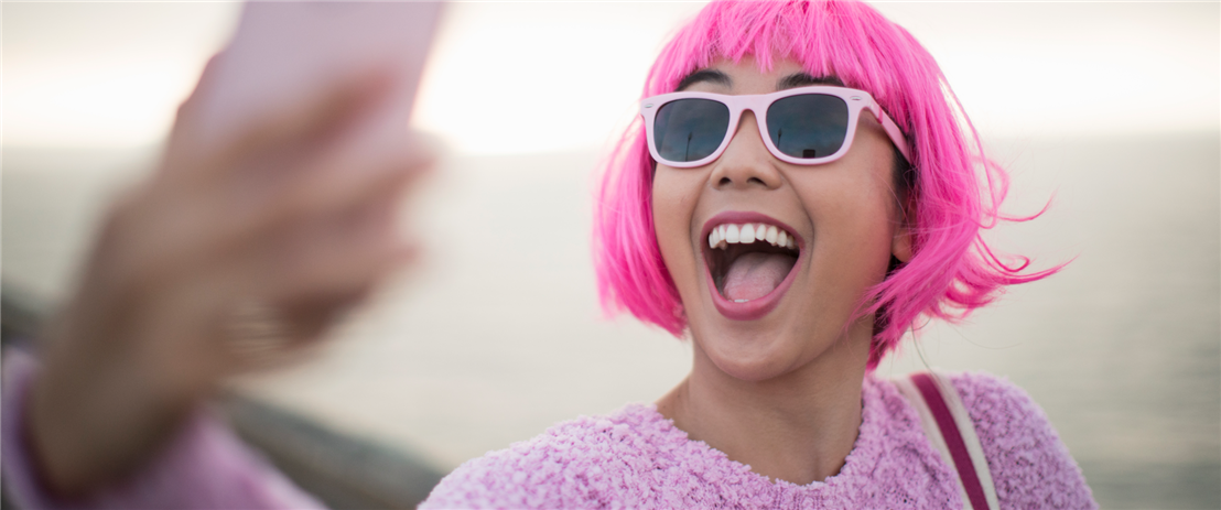 Young woman with pink hair taking selfie