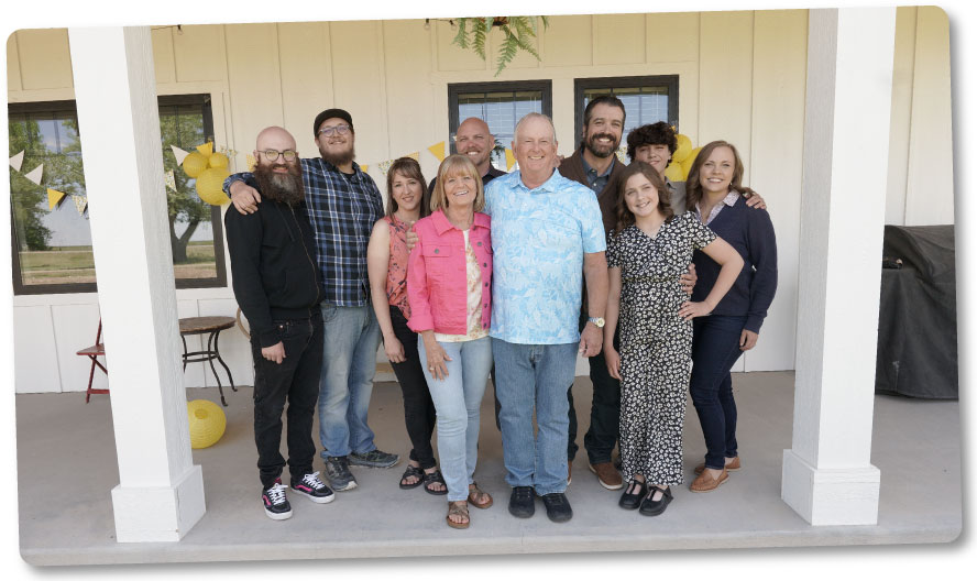 The Jones family standing on the porch smiling